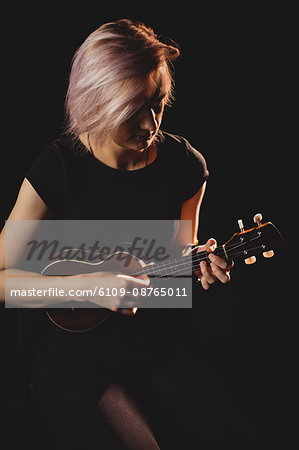 Woman playing a guitar in music school