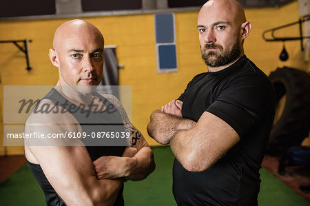 Portrait of confident thai boxers standing with arms crossed in the fitness studio