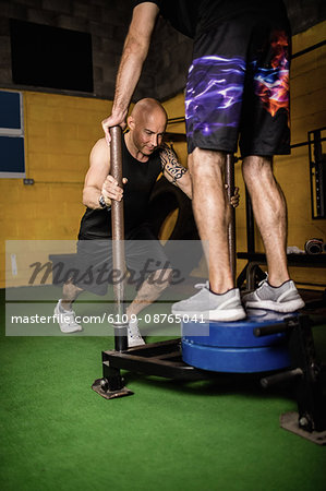 Thai boxers practicing weight exercise in the fitness studio