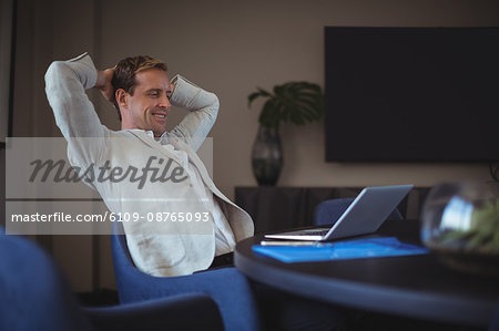 Happy businessman sitting in office