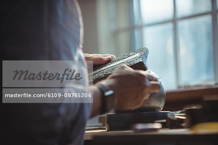 Mid-section of craftswoman working in workshop