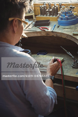 Craftswoman using blow torch in workshop