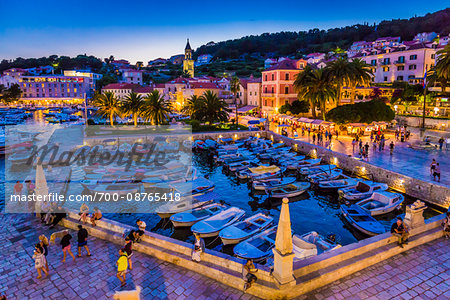 Marina and people walking along the seaside promenade at dusk in the Old Twon of Hvar on Hvar Island, Croatia