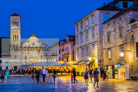 People sightseeing in St Stephen's Square with restaurant and Cahtedral of St Stephen in background in Old Town of Hvar on Hvar Island, Croatia People sightseeing in St Stephen's Square with restaurant and Cahtedral of St Stephen in background in Old Town of Hvar on Hvar Island, Croatia