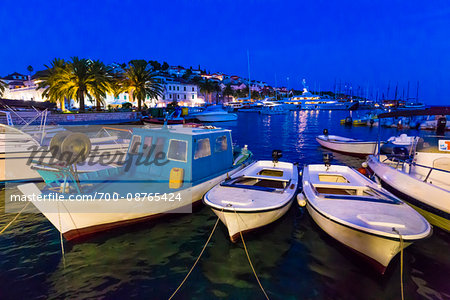 Fishing boat, motor boats and yachts in docked at marina at night in the Old Town of Hvar on Hvar Island, Croatia