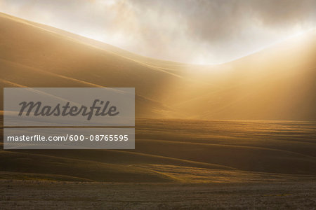 Misty sunlight over the fields at sunrise at Campo Imperatore in Abruzzo, Italy