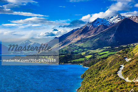 Scenic overview of mountains and Lake Wakatipu with shoreline road to Glenorchy in the Otago Region of New Zealand Scenic overview of mountains and Lake Wakatipu with shoreline road to Glenorchy in the Otago Region of New Zealand