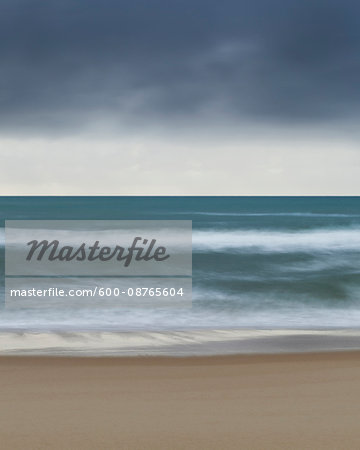 Cloudy sky over the Tyrrhenian Sea and blurred waves crashing the beach at San Felice Circeo in the Province of Latina in Lazio, Italy