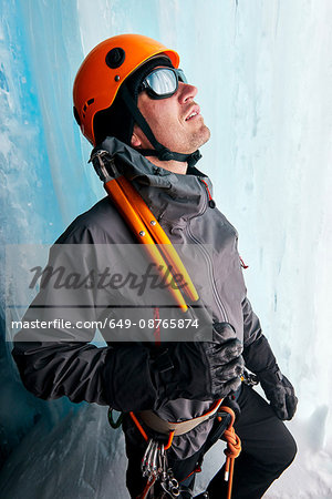 Portrait of ice climber in ice cave looking up