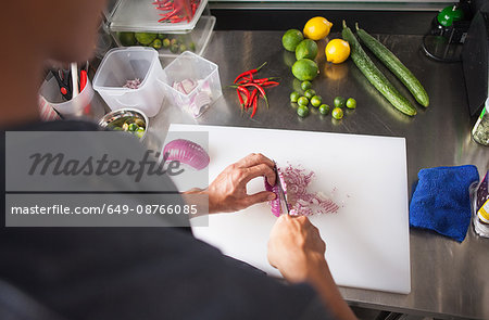 Cropped view of man slicing red onion