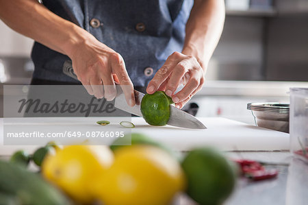 Cropped view of man slicing limes