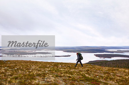 Hiker by lake, Keimiotunturi, Lapland, Finland