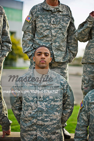 Portrait of a young US Army soldier standing with his comrades.