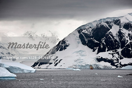 Ship passing through freezing waters and icy coastline.