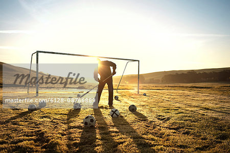 Groundskeeper raking a soccer field.