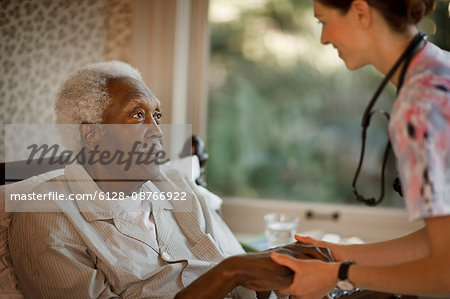 Doctor holding hands of her patient.