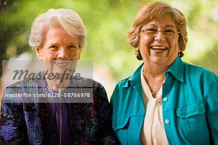 Senior woman with an oxygen nose hose (cannula) and a mature women smile as they pose for a portrait together.