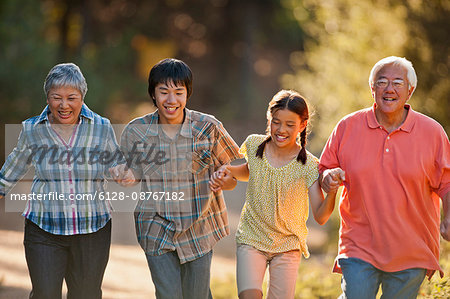 Smiling senior couple walking arm in arm with their grandchildren.