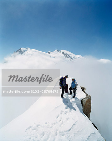 Two Mountain Climbers on a Snowy Mountain Top.