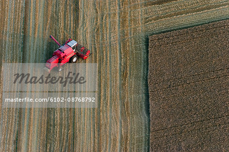 Agricultural machine in arable land, aerial view, Skane, Sweden.