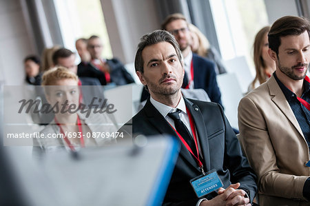 Businessman listening to presentation during seminar
