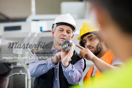 Supervisor and manual worker discussing over metal in industry