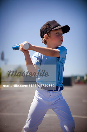 Young boy swinging a baseball bat.