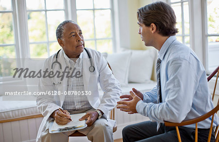 Mid adult man talking with his mature doctor.