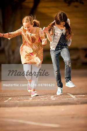 Girls playing hopscotch.