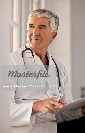 Male doctor thinking about the notes in someones file.