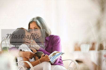 Portrait of young girl kissing her grandmother.