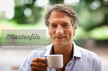 Portrait of a mature man outdoors drinking a cup of coffee.