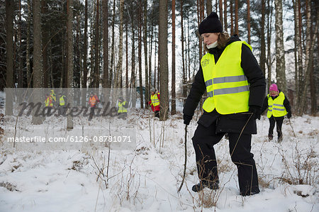 Sweden, Uppland, Upplands Vasby, Volunteers of Missing people organization in winter forest