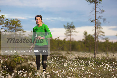 Sweden, Vasterbotten, Grossjons Nature Reserve, Woman running in meadow