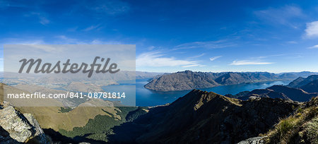 Steep sharp mountains, a deep blue lake, and mountain town in Queenstown, Otago, South Island, New Zealand, Pacific