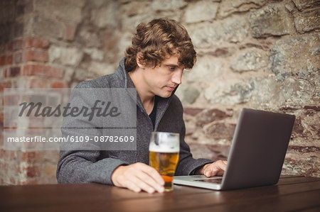 Man using laptop at bar