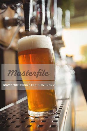 Close-up of beer glass with froth in a bar
