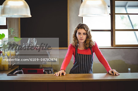 Confident waitress standing at counter in Café at bicycle shop