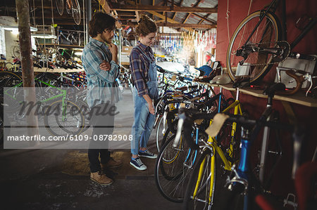 Mechanics examining a bicycle in bicycle workshop