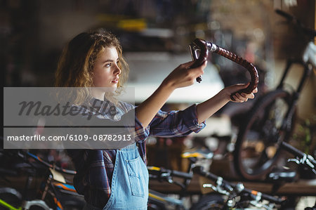 Mechanic examining a bicycle handle bar in workshop