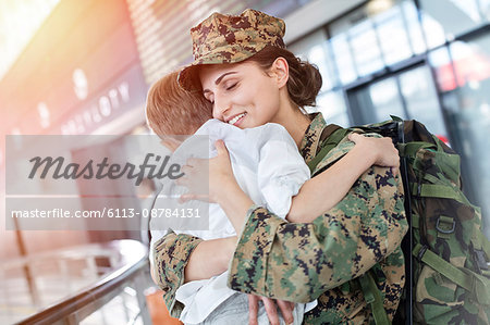 Son greeting and hugging soldier mom at airport