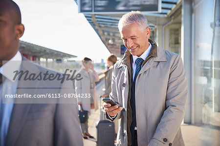 Businessman texting with cell phone outside airport