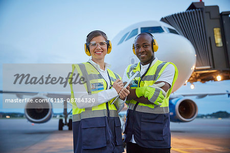 Portrait confident air traffic control ground crew workers near airplane on airport tarmac