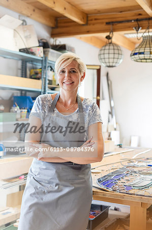 Portrait smiling stained glass artist in studio