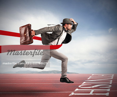 Businessman with bag goes beyond the red ribbon at the arrival of a race