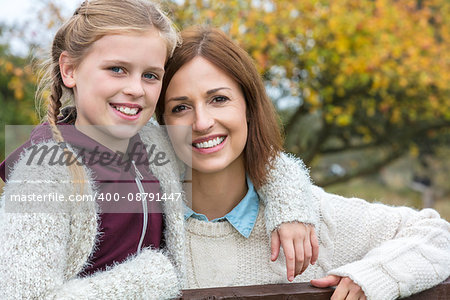 Portrait shot of an attractive, successful and happy middle aged woman female outside smiling with her female child daughter
