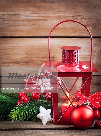 Christmas time red latern with candle light and holiday decorations around, copy space