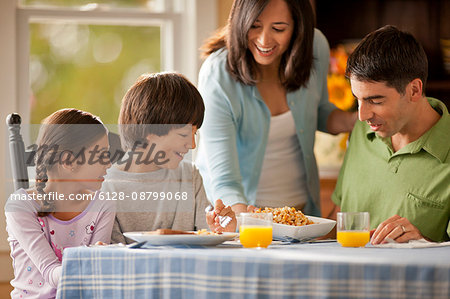 Happy family having fun eating at a dining table.