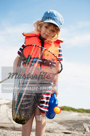 Girl wearing life jacket holding butterfly fishing net