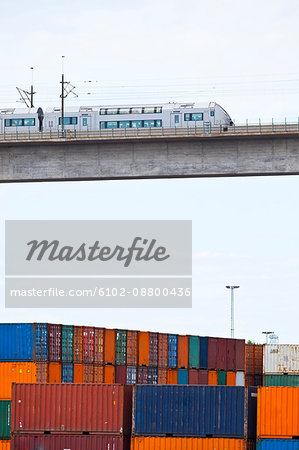 Monorail on elevated bridge over cargo containers